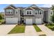 Daytime view of inviting townhomes, showcasing garages, and well-manicured lawns at 5625 Axil Ln, Charlotte, NC 28269