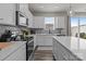 Bright kitchen featuring white cabinets, a gray backsplash, stainless appliances, and a kitchen island at 5625 Axil Ln, Charlotte, NC 28269