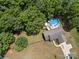 Aerial view of a home with in-ground pool, large backyard, surrounded by lush greenery and mature trees at 5764 Grassy Creek Rd, Denver, NC 28037