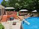 Outdoor living space featuring a refreshing pool, multi-level deck, and ample seating for a relaxing and fun environment at 5764 Grassy Creek Rd, Denver, NC 28037