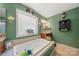 Relaxing soaking tub with window view, complemented by a stylish vanity and decor at 5764 Grassy Creek Rd, Denver, NC 28037