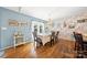 Bright dining room with hardwood floors, decorative wallpaper, and a chandelier over the table at 5764 Grassy Creek Rd, Denver, NC 28037