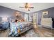 Charming main bedroom featuring floral bedding, ceiling fan, and hardwood floors at 5764 Grassy Creek Rd, Denver, NC 28037