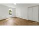 Bright bedroom with wood-look flooring, a window, closet space, and neutral walls at 60 Valley Nw St, Concord, NC 28025