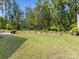 Spacious backyard featuring a lush lawn and mature trees creating a serene and private outdoor space at 603 Southstone Dr, Matthews, NC 28104