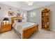Comfortable bedroom with natural light, featuring a wooden bed frame and golf-themed decor at 603 Southstone Dr, Matthews, NC 28104