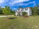 Spacious two-story home with white siding, complemented by a lush green lawn and manicured landscaping at 603 Southstone Dr, Matthews, NC 28104