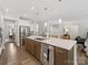 Open concept kitchen features a large island, breakfast bar, stainless steel appliances, and wood cabinets at 603 Southstone Dr, Matthews, NC 28104