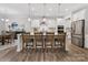 Kitchen island with breakfast bar seating, stainless steel appliances, and pendant lighting, adjacent dining area at 603 Southstone Dr, Matthews, NC 28104