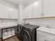 Well-lit laundry room with modern washer/dryer and ample cabinet storage at 603 Southstone Dr, Matthews, NC 28104