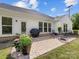 White siding home's brick patio boasts a grill, table, chairs, and potted plants, ideal for outdoor dining and relaxation at 603 Southstone Dr, Matthews, NC 28104