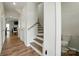 Open hallway view with wood floors, staircase, and partial view of a half bathroom at 6037 Chelsea Oaks Rdg # 77, Tega Cay, SC 29708