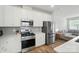 Modern kitchen featuring stainless steel appliances, white cabinets, and gray backsplash at 6037 Chelsea Oaks Rdg # 77, Tega Cay, SC 29708