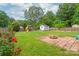 Spacious backyard featuring a fire pit, playset, storage shed, garden bed and beautiful rose bushes at 618 Heathermoor Ct, Charlotte, NC 28209