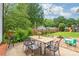 Picturesque backyard with a wooden table and chairs, lush greenery, and a playhouse at 618 Heathermoor Ct, Charlotte, NC 28209