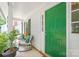 Cozy front porch with comfortable seating beside a vibrant green front door, creating a welcoming entrance to the home at 618 Heathermoor Ct, Charlotte, NC 28209