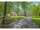 Charming two-story home with a lush, green lawn and mature trees creating a serene, shaded landscape at 618 Heathermoor Ct, Charlotte, NC 28209