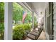 Inviting front porch featuring a charming porch swing, perfect for enjoying the view of the lush green lawn and street at 618 Heathermoor Ct, Charlotte, NC 28209