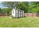 Backyard shed with double doors, potted plants, and a garden bed, providing ample storage at 618 Heathermoor Ct, Charlotte, NC 28209
