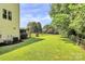 Lush backyard with mature trees, manicured lawn, and a charming fence at 655 Powder Horn Ln, Indian Trail, NC 28079