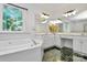 Bright bathroom featuring a luxurious soaking tub, black tile floor, and a double vanity at 655 Powder Horn Ln, Indian Trail, NC 28079