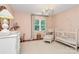 Charming Bedroom featuring soft pink walls, a crib, changing table, and a cozy armchair, perfect for a baby at 655 Powder Horn Ln, Indian Trail, NC 28079