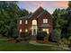 Elegant two-story brick home with a manicured lawn, beautiful front door, and warm lighting at 655 Powder Horn Ln, Indian Trail, NC 28079