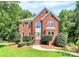 Charming two-story brick home with manicured lawn and mature trees at 655 Powder Horn Ln, Indian Trail, NC 28079