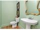 Charming powder room with a pedestal sink, ornate mirror, and tasteful wall art at 655 Powder Horn Ln, Indian Trail, NC 28079