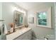 Bright bathroom with a modern vanity, updated fixtures and natural light from the window at 6621 Ronda Ave, Charlotte, NC 28211