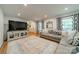 Bright living room showcasing a comfortable sectional sofa, large windows, and hardwood flooring at 6621 Ronda Ave, Charlotte, NC 28211