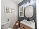 Stylish powder room with a wood vanity, modern lighting, and decorative accents at 6621 Ronda Ave, Charlotte, NC 28211