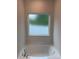 Soaking tub under a frosted window in a well-lit bathroom is perfect for relaxation and privacy at 7 Scott Sw St, Concord, NC 28025