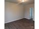 Bright bedroom with neutral walls, wood floors, and a doorway to an adjacent room and a closet at 7 Scott Sw St, Concord, NC 28025