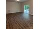 Spacious living room featuring wood flooring, neutral walls, and sliding glass door leading to outdoor space at 7 Scott Sw St, Concord, NC 28025