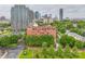 A red brick apartment building is nestled among greenery with downtown buildings in the background at 715 N Church St # 613, Charlotte, NC 28202