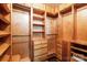 Spacious walk-in closet features custom wooden shelving, drawers, and ample storage for clothing and accessories at 715 N Church St # 613, Charlotte, NC 28202