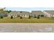 Backyard view from a paved patio overlooking green grass, fences, and neighbors at 7332 Jolly Brook Dr, Charlotte, NC 28215