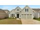 Charming home with light gray siding, blue shutters, a two-car garage, and a well-manicured lawn at 7332 Jolly Brook Dr, Charlotte, NC 28215