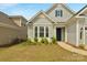 Well-kept front yard with flowering shrubs and healthy green grass leads to a home with blue shutters at 7332 Jolly Brook Dr, Charlotte, NC 28215