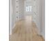 Bright hallway featuring light wood floors, white trim and doors, and views of the living area at 7332 Jolly Brook Dr, Charlotte, NC 28215