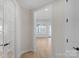 Hallway featuring light wood floors, white trim and doors, and views of the living area at 7332 Jolly Brook Dr, Charlotte, NC 28215