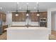 Bright kitchen featuring stainless steel appliances, custom cabinets, a gas cooktop, and a large island at 7332 Jolly Brook Dr, Charlotte, NC 28215
