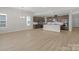 Open concept living room with modern kitchen and bright lighting and wood floors at 7332 Jolly Brook Dr, Charlotte, NC 28215