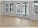 A close up view of the living room's wood floor, multiple windows and glass patio doors at 7332 Jolly Brook Dr, Charlotte, NC 28215