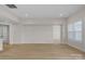 A large empty living room with wood floor, a window, and a doorway to the pantry at 7332 Jolly Brook Dr, Charlotte, NC 28215