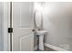 Half-bath features modern fixtures including an oval mirror and pedestal sink at 7517 Lancaster Hwy # 5, Waxhaw, NC 28173