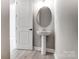 Half-bath featuring a single sink and a modern oval mirror at 7517 Lancaster Hwy # 5, Waxhaw, NC 28173