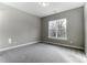 Bedroom with neutral carpet, light-gray walls, white trim, and large window at 7517 Lancaster Hwy # 5, Waxhaw, NC 28173