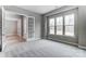 Bright bedroom with three windows, gray walls, and plush gray carpet flooring at 7517 Lancaster Hwy # 5, Waxhaw, NC 28173